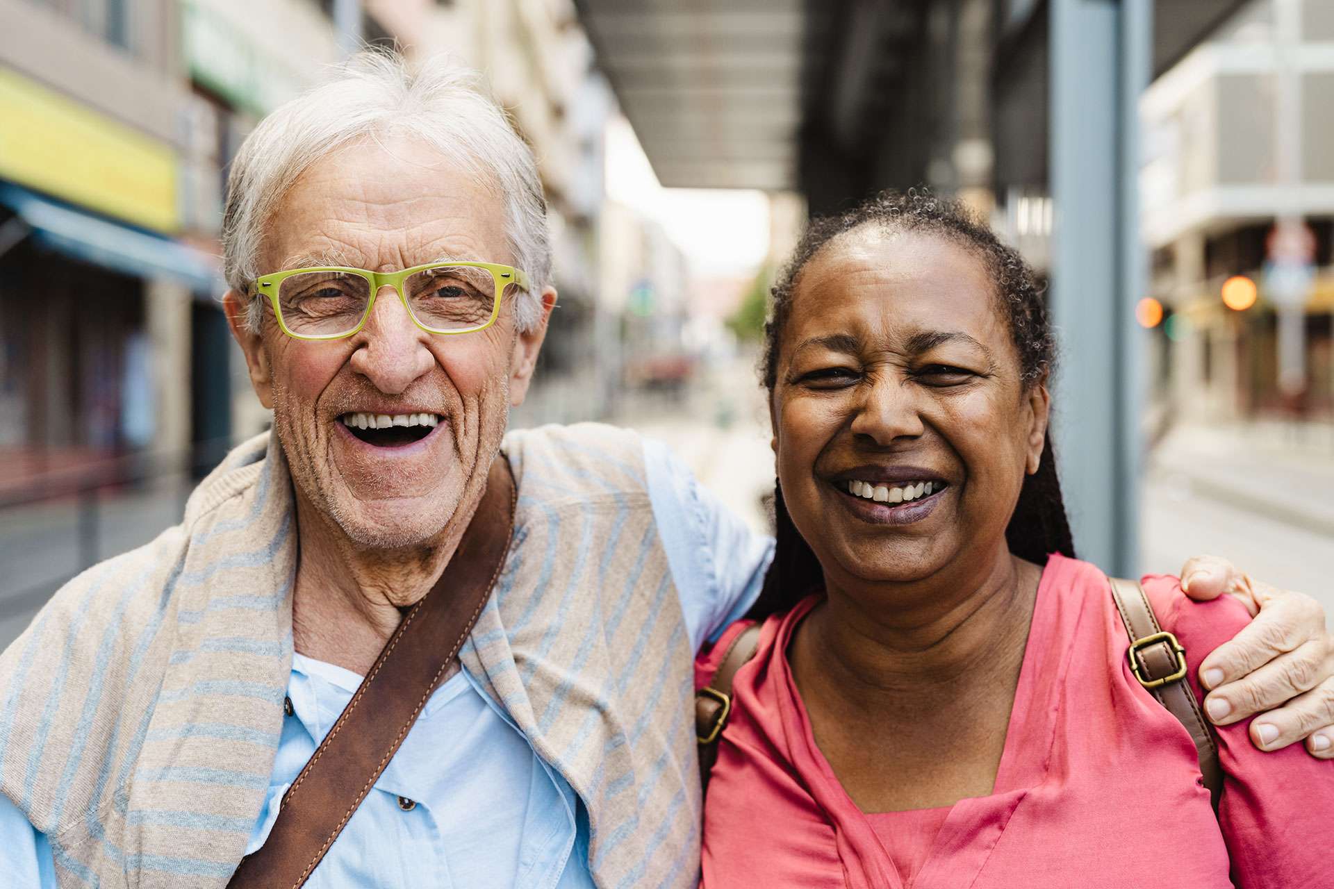 Elderly friends laughing together on a city street.
