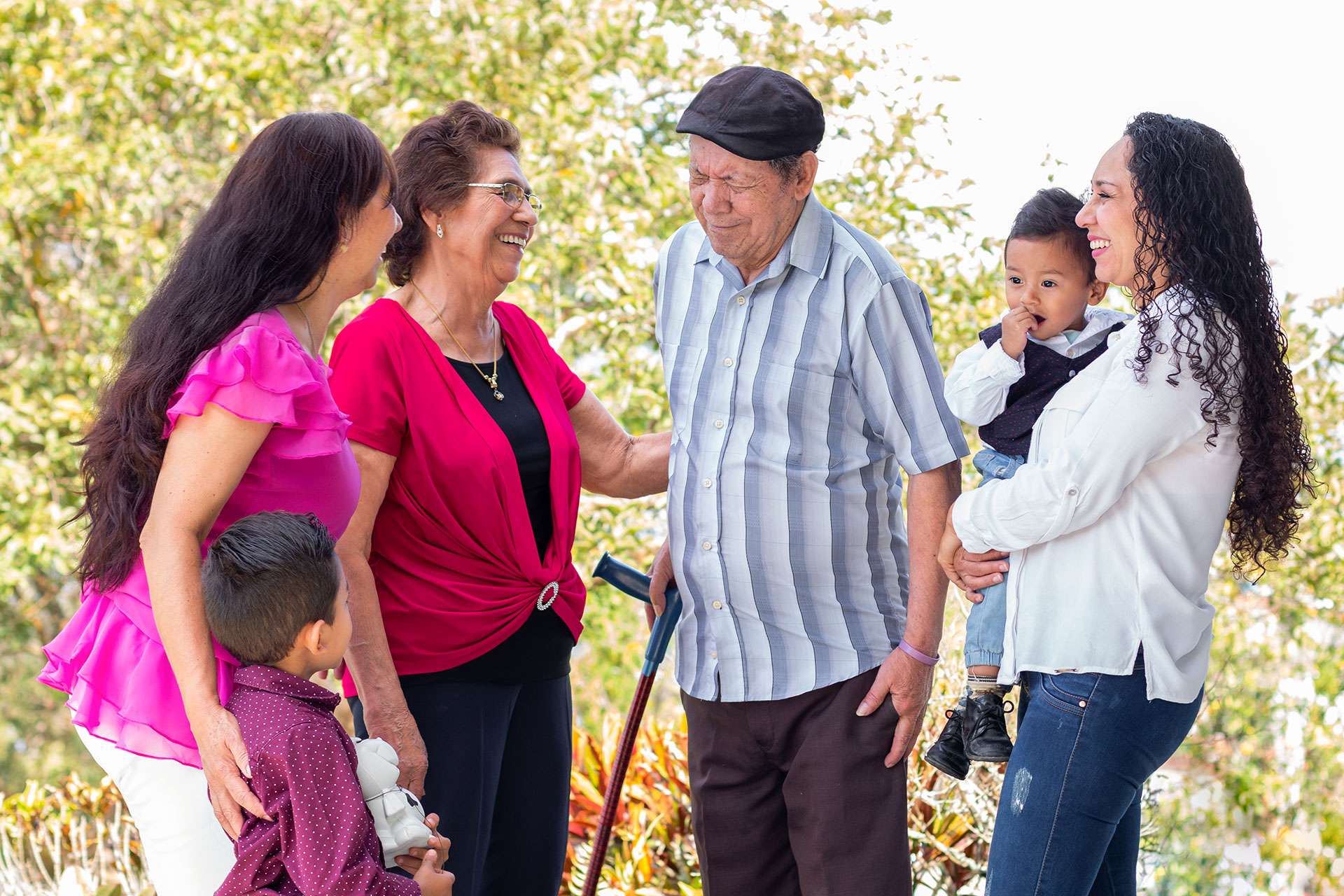 Family gathering outdoors, smiling and interacting joyfully.